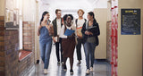 Students walking in a high school hallway laughing and smiling, pictured on the wall is a SCOPE-IT self-regulation strategy poster